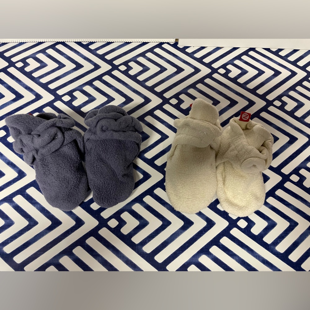 Two pairs of Zutano Booties. Ivory pair is 24 months, blue pair is 18 months.